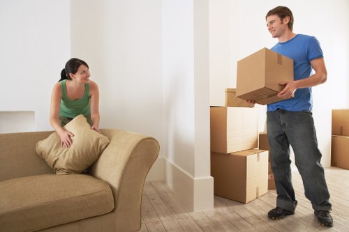 Removal staff carrying furniture carefully down stairs