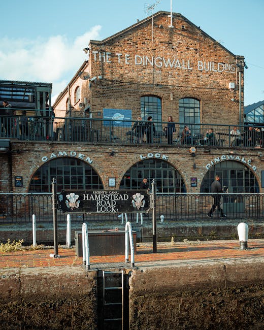 A multi-storey brick building with signage indicating 'The Tingwall Building' on the upper level and 'Camden Lock' on the lower level, situated alongside the Regents Canal. The building features large